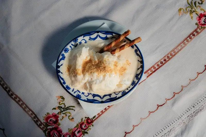 Šne nokle in una ciotola, con crema e cialde arrotolate